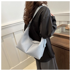 Detail of light blue woven PU leather hobo bag with adjustable strap and silver buckle