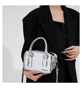 Detail view of silver mirror PU leather crossbody bag with metallic sheen and top handle