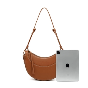 Detailed view of a brown pebbled PU leather crescent bag with white contrast stitching