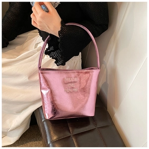 Gros plan sur un sac seau rose métallisé avec finition brillante et poignée fixe élégante