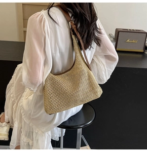 Detail view of woven khaki hobo bag with brown leather strap and silver adjustable buckle