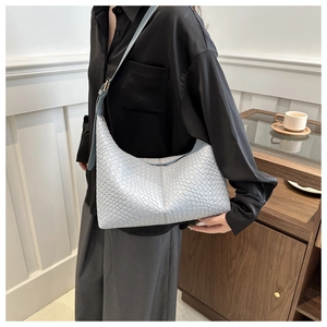 Close-up of a light blue woven hobo bag showing checkered texture and shoulder strap