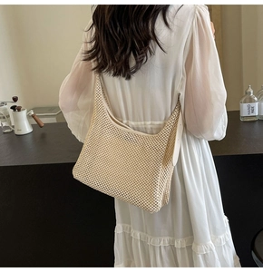 Detailed texture of the beige woven mesh crossbody bag in a minimalist lifestyle setting