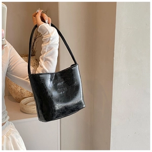 Détail du sac d'épaule en PU noir brillant avec texture vintage et imprimé tendance