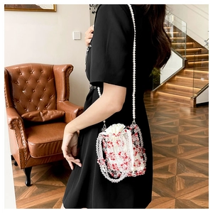 Detail of beaded floral handbag with red and clear beads and white satin drawstring pouch