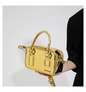 Detail of trendy metallic gold PU leather crossbody bag with mirror finish and dual handles