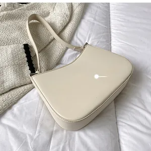 Rear view of cream underarm bag showing smooth faux leather texture on textured fabric