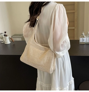 Vista dettagliata della borsa a tracolla in paglia beige intrecciata con trama a rete