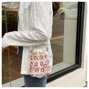 Detail of red and clear beaded crossbody bag with white satin drawstring liner and pearl charm