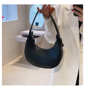 Close-up of black leather crescent hobo bag with silver zipper detail and smooth matte finish