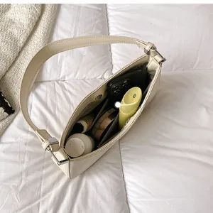 Internal storage view of the cream leather half-moon shoulder bag with daily essentials