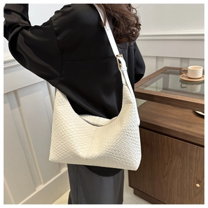 Detail shot of white woven PU leather shoulder bag featuring refined cross-pattern texture