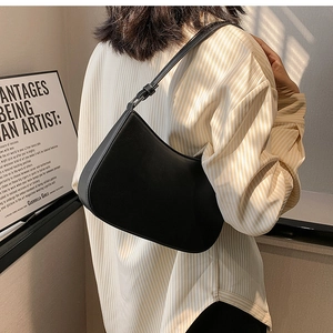 Minimalist black crescent shoulder bag with smooth leather finish and adjustable strap
