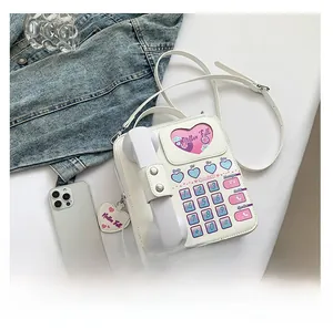 Détail du sac à bandoulière créatif en cuir PU blanc en forme de téléphone avec breloques