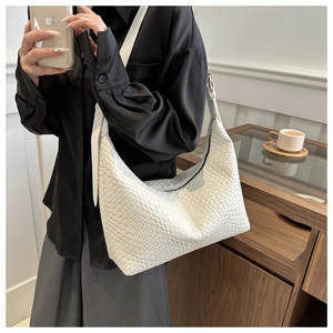 Detail of white woven PU leather hobo bag with textured pattern and adjustable strap