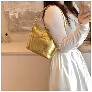 Détail du sac bandoulière en PU doré métallisé avec logo de marque porté par le mannequin