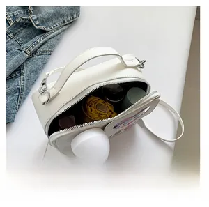 Capacité interne du sac bandoulière en cuir blanc avec parapluie et cosmétiques