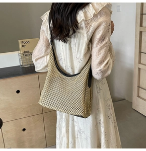 Dettaglio della borsa hobo in paglia intrecciata con finiture in pelle marrone scuro