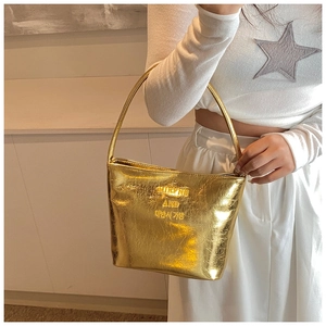 Détail d'un sac seau en cuir doré avec finition métallisée et fine bandoulière