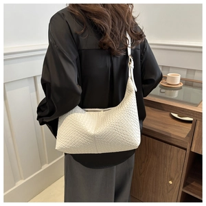 Close-up of white woven PU leather handbag showing chessboard texture and gold hardware