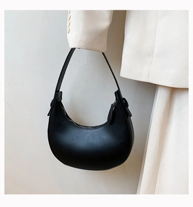 Minimalist black PU leather crescent underarm bag shown with a white blazer outfit