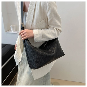 Detailed view of black PU woven texture on a minimalist crescent crossbody shoulder bag