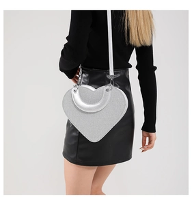 Détail du sac à main en forme de cœur avec poignée en U argentée et texture pailletée