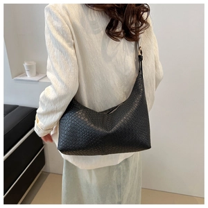 Detail of black woven texture on a PU leather Hobo bag with adjustable shoulder strap