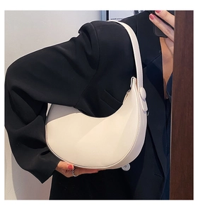 Chic cream white leather hobo bag shoulder view on model with elegant black blazer contrast