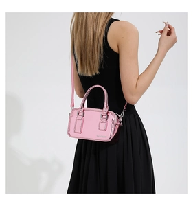 Chic metallic pink PU leather crossbody bag with silver hardware on black dress model