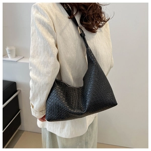 Detail of black faux leather hobo bag with embossed texture and adjustable strap