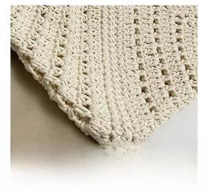 Detail shot of cream white hand-knitted handbag showing intricate hollow wave patterns