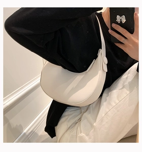 Mirror selfie showing a white crescent shoulder bag in a minimalist style for women