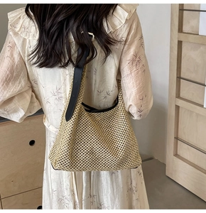 Vista dettagliata della borsa a tracolla beige in paglia intrecciata con spallina in pelle