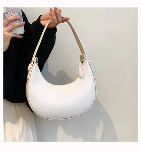 Detailed close-up of a cream PU leather half-moon shoulder bag with a wide strap design