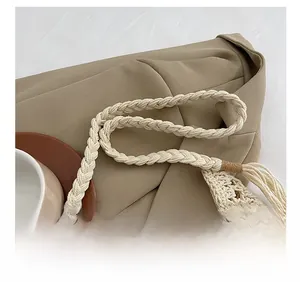 Detail shot of the chunky rope shoulder strap and crochet knit texture on a beige handbag