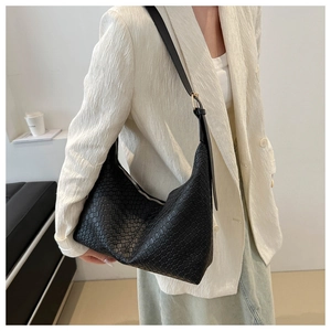 Detail shot of black woven hobo shoulder bag with adjustable strap and zip closure