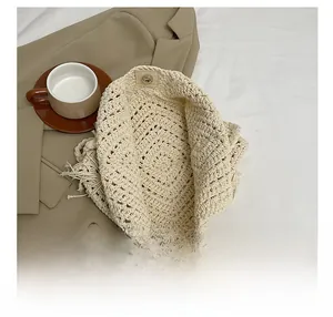 Detail of knit handbag with magnetic clasp and fringe trim in beige textured fabric