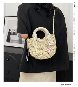 Vue détaillée du sac à main en paille avec broderie de cerisier et nœud en dentelle