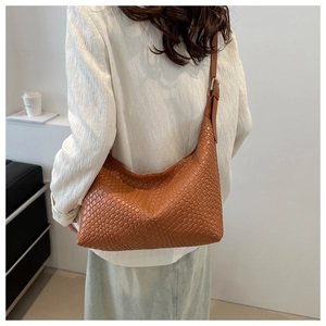 Detailed view of the woven brown PU leather texture and shoulder strap on hobo bag