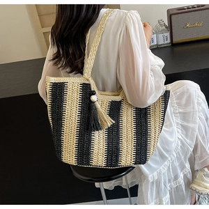 Detail of hand-woven striped tote bag with elegant tassels and beads for women
