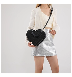 Détail macro du sac en forme de cœur à paillettes noires avec fermeture éclair en métal