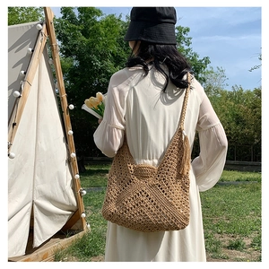 Detail of hand-woven hobo bag in light brown knit texture with stylish fringe tassel