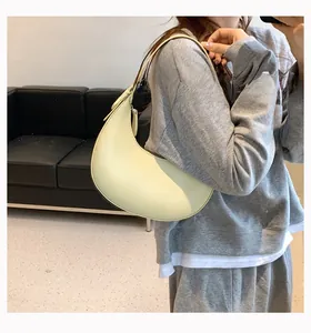 French style creamy yellow crescent underarm bag shown on model in modern room