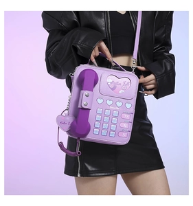 Close-up of vintage purple telephone shaped crossbody bag with heart shaped window detail