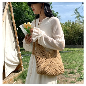 Close-up of beige crochet hobo bag showing intricate knit texture for summer beach use