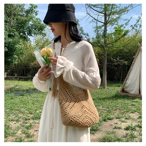 Outdoor shot of a khaki crochet knit tote bag with geometric patterns for summer beach vacation