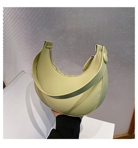 Detail of light yellow crescent shoulder bag featuring smooth PU leather and top zipper