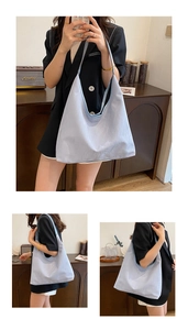 Détail du sac cabas en tissu plissé bleu clair montrant sa texture douce et sa grande taille