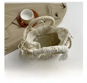 Détail de l'intérieur du sac en paille avec doublure à cordon et bordure en dentelle blanche